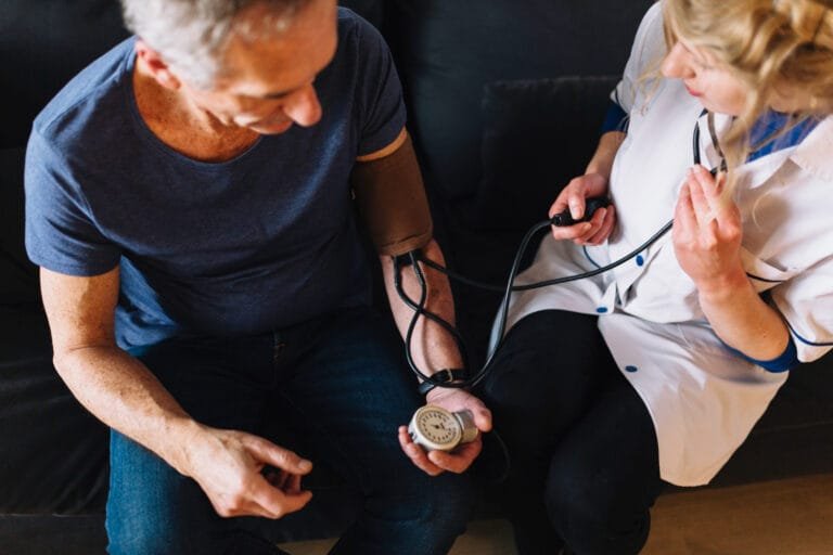 Home Understanding Hypertension – Healthcare professional checking blood pressure for heart health assessment