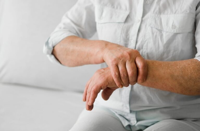 Home Person holding their wrist in discomfort, showing arthritis symptoms.