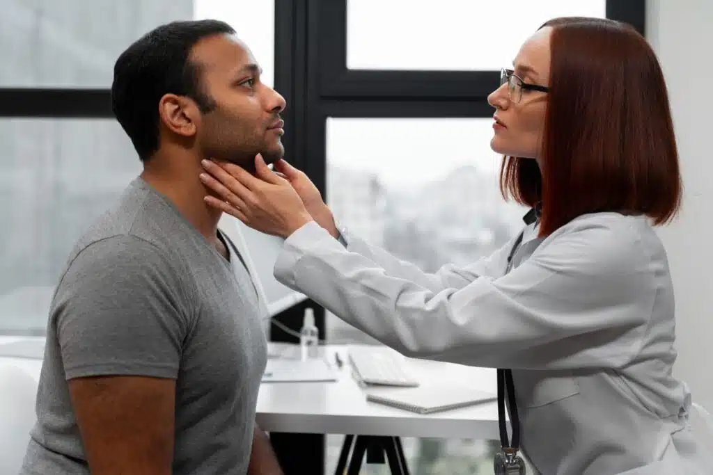 A doctor examines a patient’s neck for thyroid abnormalities during a routine check-up.